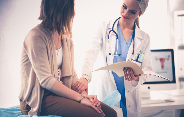 Doctor and patient discussing something while sitting at the table .